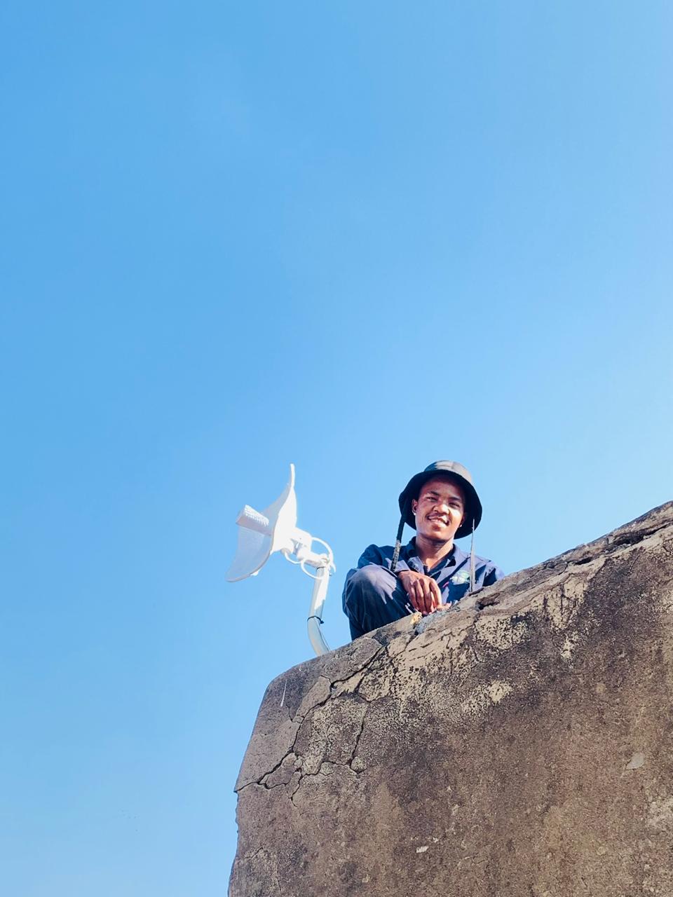 LTO Telecoms technician on a high-site tower with a wireless dish antenna